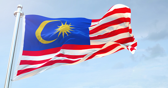 National Flag of Malaysia Against Defocused City Buildings