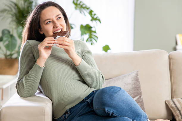 istock Woman biting a chocolate bar 1317750423
