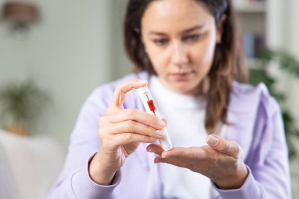 istock Young woman doing blood sugar test at home 1317750459