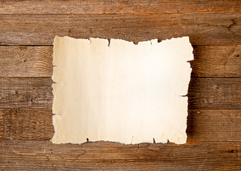 blank sheet of yellowed old papyrus with blank space for inscription on rough wooden background