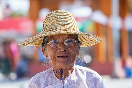 Inle lake, Myanmar, Burma - jan 12, 2016 : Old woman in a straw hat . The local people are hospitable and friendly to tourists, Inle lake, Myanmar, Burma