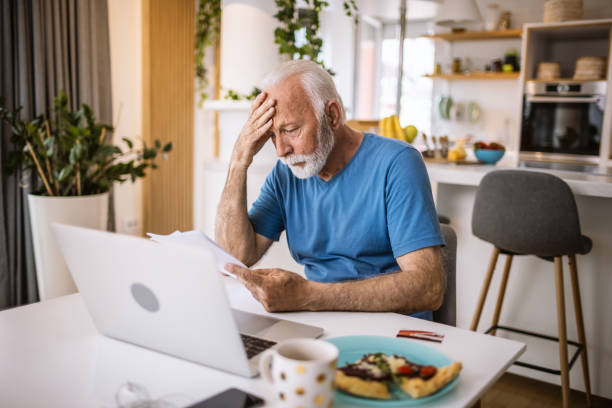istock Senior Man Checking Bills at Home 1317758780