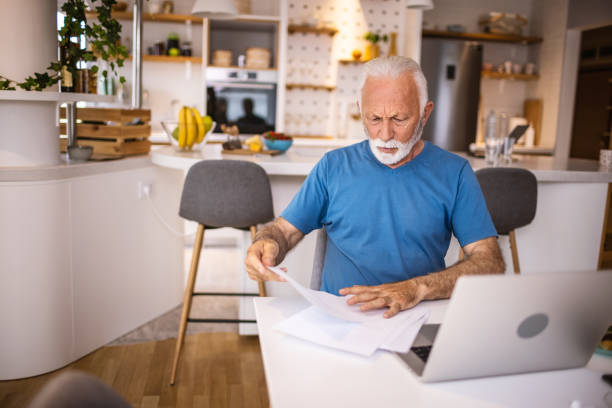 istock Senior Man Checking Bills at Home 1317758822