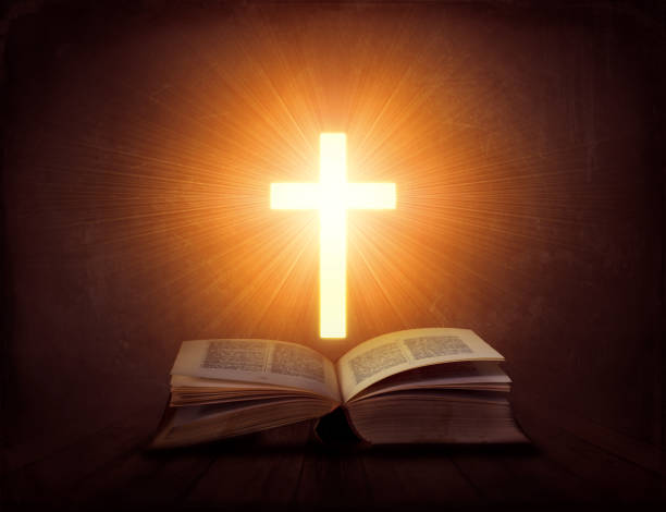 istock Open book with glowing cross above it; religion concept 1317759074