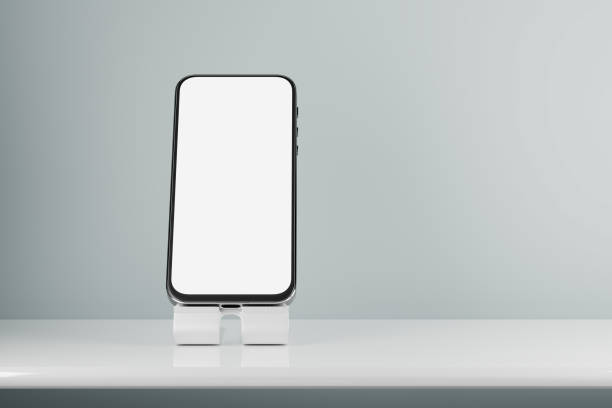 istock Smartphone mockup with white screen. A mockup of a smartphone on a stand on the table. 3d rendering. 1317760212