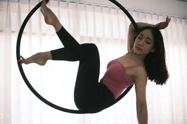 Young sports girl dancing with an air hoop.