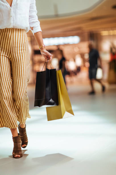 Life isn't perfect but your outfits can be Unrecognisable woman walking through the shopping mall while holding paper shopping bags shopping bag stock pictures, royalty-free photos & images