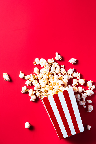 Cinema Popcorn Strtiped Box. Red Border Background. Watching Movies Concept. Flat Lay Still Life Image.