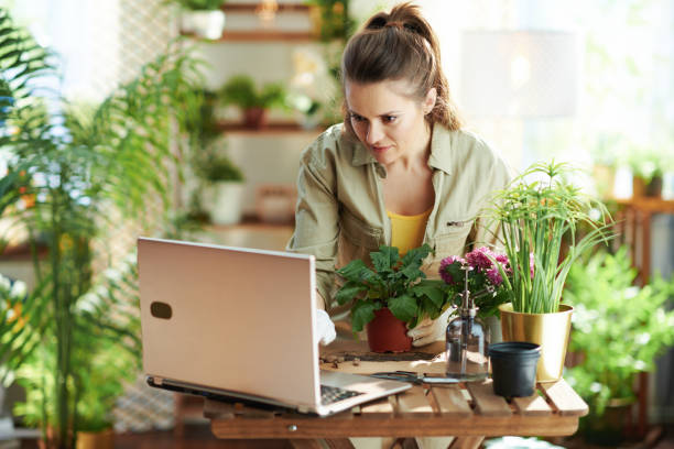 istock florist in rubber gloves in sunny day using laptop 1317771338