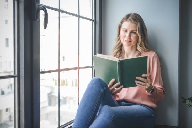 istock attractive middle aged woman in the office ( reading a book) 1317778324