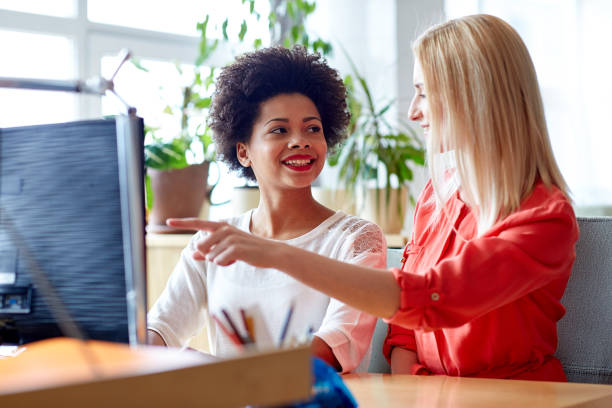 istock happy women or students with computer in office 1317780364