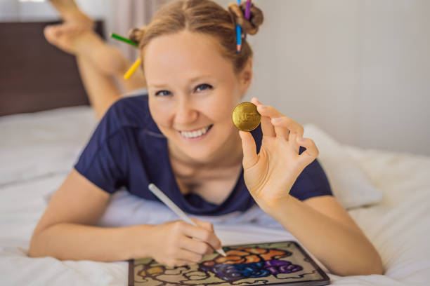 nft jeune femme, un artiste numérique, crée de l’art numérique sur une tablette à la maison et montre une pièce avec l’inscription ntf - jeton non fongible. travail à distance, nomade numérique, peinture numérique, animation, vidéo - newspaper the media digital tablet digitally generated image photos et images de collection