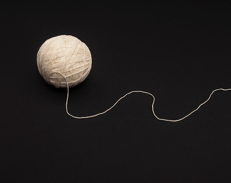 A ball of  yarn on a black background .