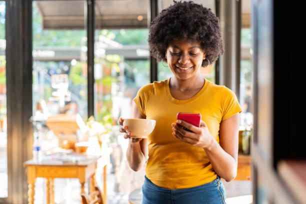 donna in caffetteria con cellulare - starbucks women walking restaurant foto e immagini stock