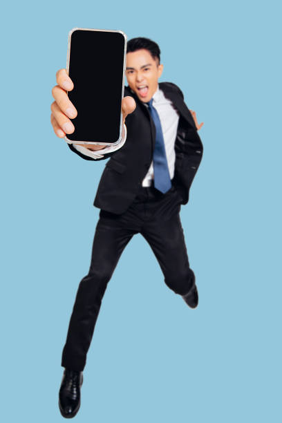 istock Excited Young business man dancing and showing the  mobile phone screen 1317782721