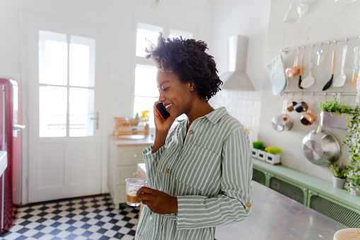 Young woman starting the day with morning coffee and a phone call