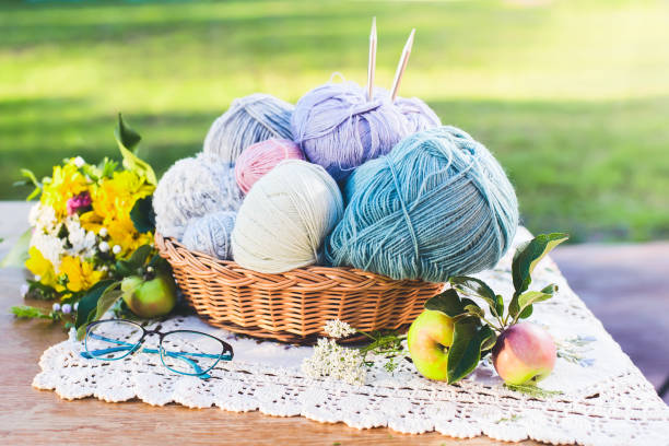 女性の趣味。日当たりの良い夏の日に庭の木製のテーブルの上に編み物や編み物が必要です。 - nobody wool multi colored love ストックフォトと画像