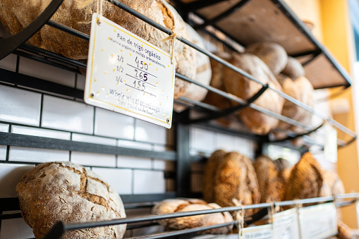 Bakery products on the rack with a price board hanging. Food displayed for sale in a coffee shop.