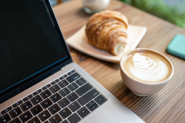 카페 테이블에 노트북 컴퓨터와 크루아상과 라떼 아트 커피 - cafe breakfast coffee croissant 뉴스 사진 이미지