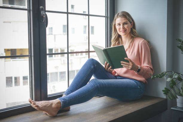 istock attractive middle aged woman in the office ( reading a book) 1317789437