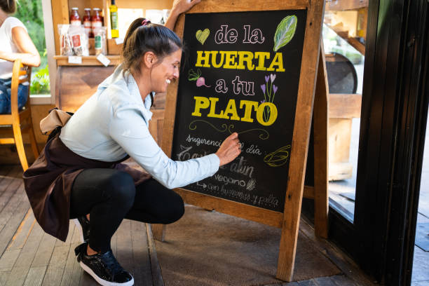 istock Cafe owner writing special menu on the chalkboard 1317789519