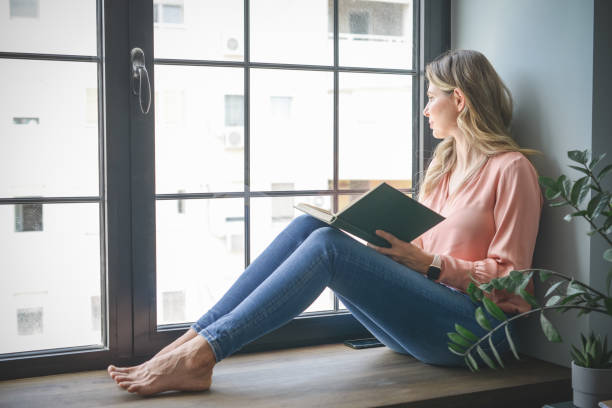 istock attractive middle aged woman in the office ( reading a book) 1317790549