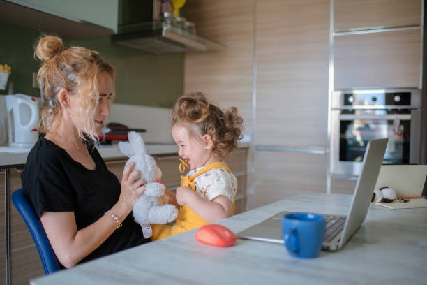 istock Mother playing game with her baby between online meeting. 1317790583