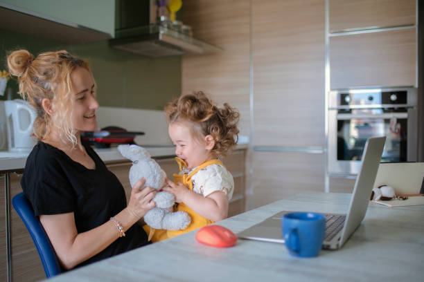 istock Mother playing game with her baby between online meeting. 1317790743