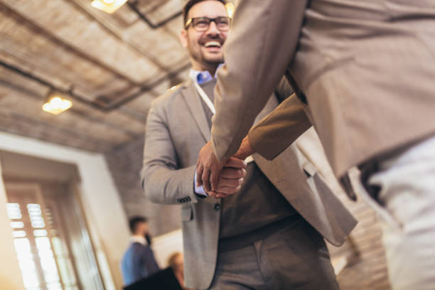 istock Young modern men in smart casual wear shaking hands while working in the creative office 1317792525