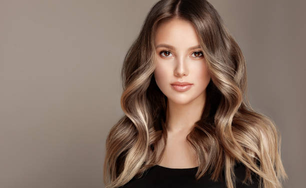 young, brown haired beautiful model with wavy, dense, dyed long hair. excellent hair waves.hairdressing art and coloration of hair. - attractive female indoors lifestyles clean imagens e fotografias de stock