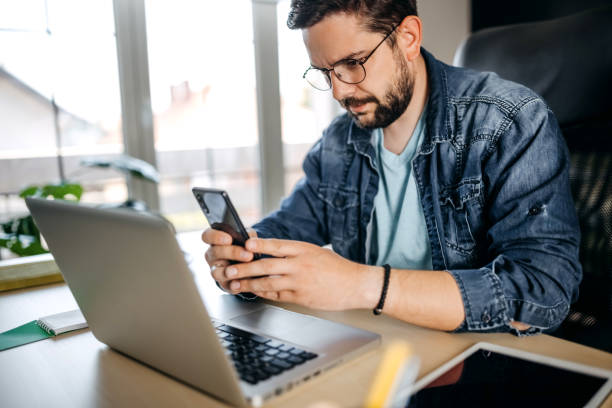 istock Cheerful man using smart phone at home office 1317794814