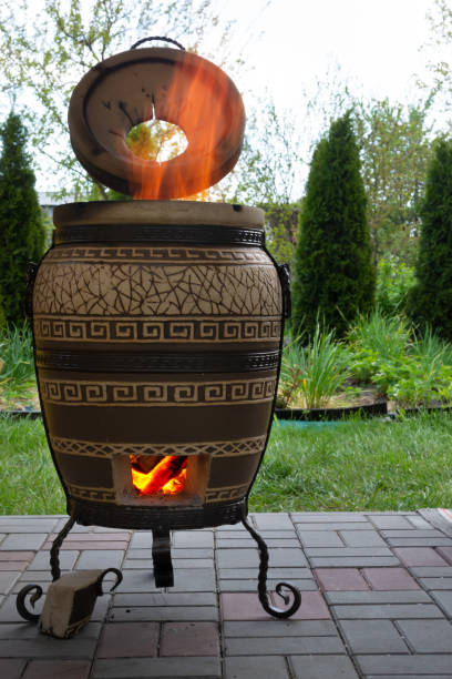 Traditional tandoor oven. Fire in the tandoor. Vertical orientation. stock photo