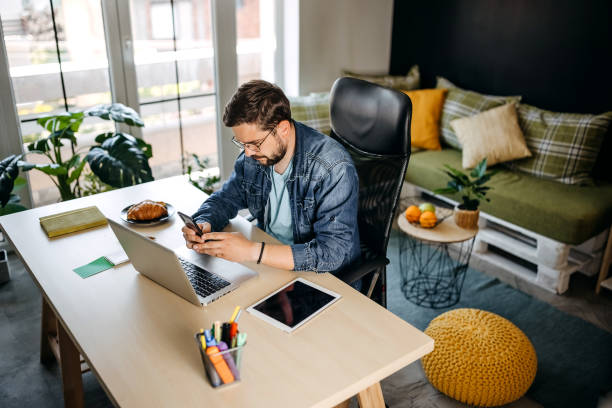 istock Cheerful man using smart phone at home office 1317795410