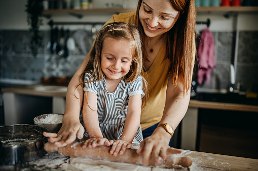 Happy family. Mom and daughter prepare pastries in the kitchen. The concept of a loving family and family values. Healthy home food.