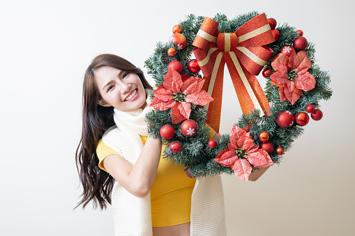 Bride with spring flower wreath in her hands isolated on a gray background.