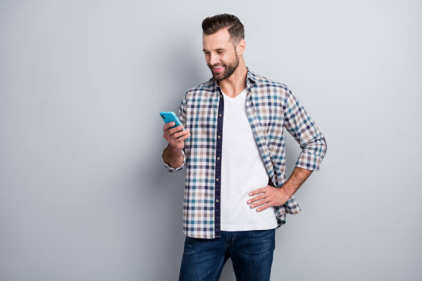 istock Photo portrait of man using cellphone browsing internet isolated on grey color background with empty space 1317799837