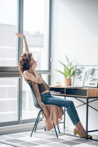 istock Dark-haired woman sitting with telephone in hands 1317803575