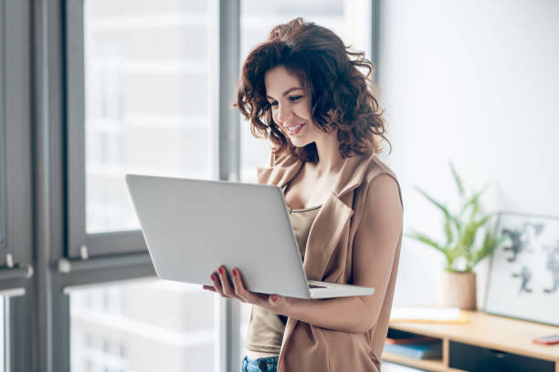 istock Dark-haired pretty woman working on a laptop and looking concentrated 1317803603