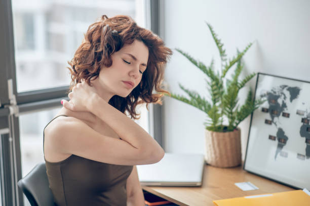 istock Woman tocuhing her aching neck while resting after a hard working day 1317803606