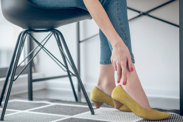 istock Woman touching her aching feet in a new shoe 1317803619