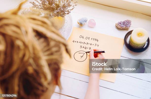 Above View Of Girl Calculate Life Path Number On Paper In Home Spiritual Numerology Concept Stock Photo - Download Image Now