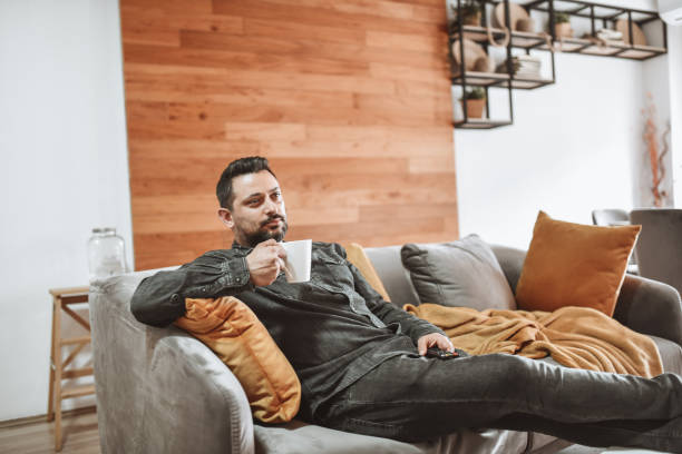 istock Coffee Time For Modern Male Relaxing On Living Room Sofa 1317807415