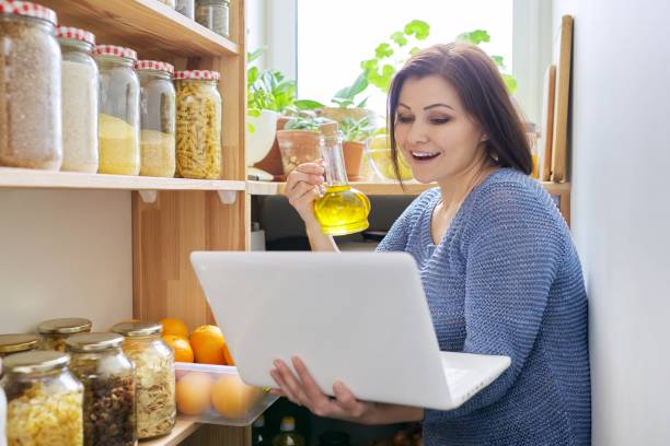 istock Home pantry kitchen interior, woman with laptop recording vlog, storage organization 1317808029