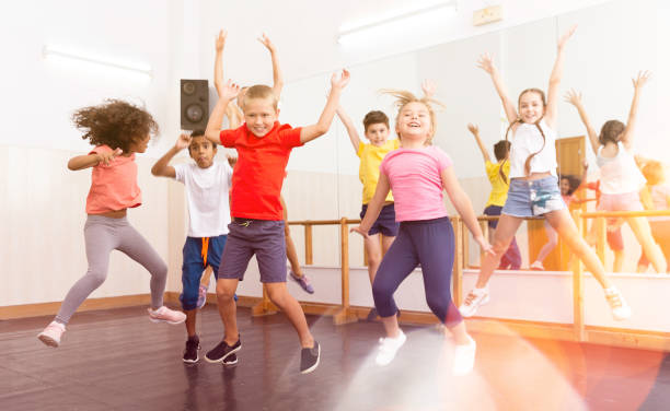 istock Happy sporty kids jumping together in dance studio 1317812024