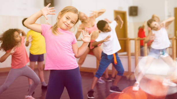 istock Smiling little girl training vigorous dance in children dance studio 1317812099