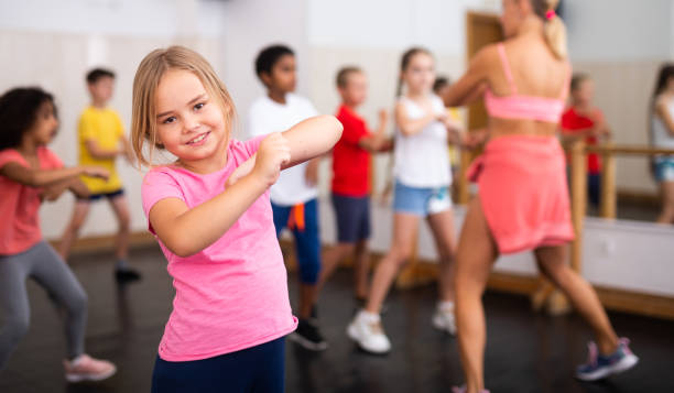 istock Smiling little girl training movements in children dance studio 1317812102
