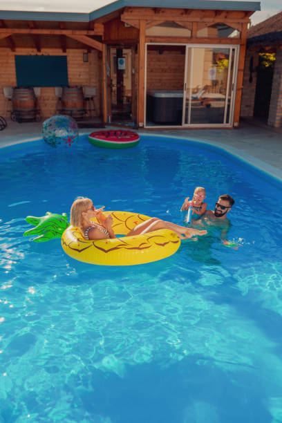 istock Parents playing with daughter at the swimming pool 1317812766
