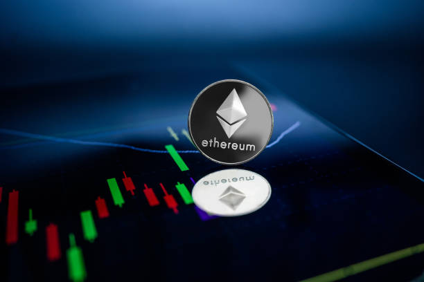 Ethereum coin is placed on a laptop showing a graph screen. Ethereum coin is placed on a laptop showing a graph screen. ethereum stock pictures, royalty-free photos & images
