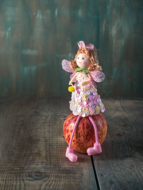 Fabulous postcard. Apple fairy sitting on an apple on a brownish background