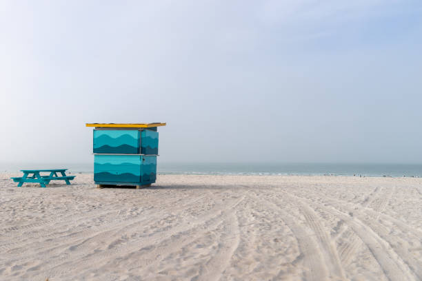 View of the Gulf of Mexico on an overcast morning with blue picnic table and closed cabanna